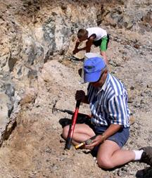 Dave examins Thunder Egg while Kyle digs in background